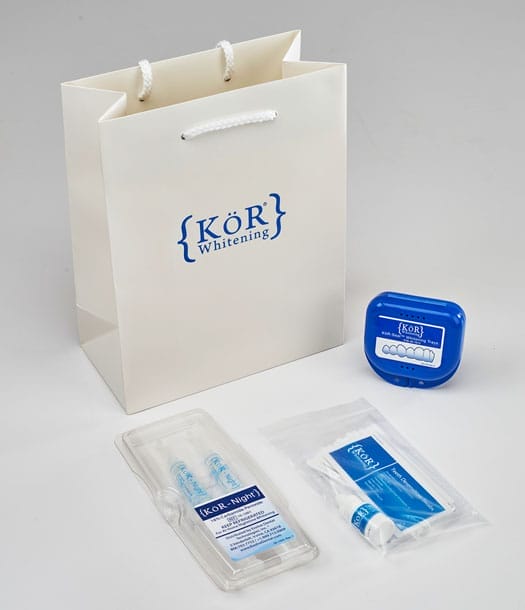 KöR Whitening kit with a bag, whitening trays, gel syringes, and instructions