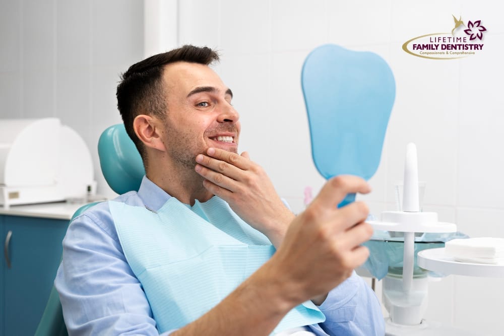 Man examining his teeth in the mirror, checking the results of teeth whitening treatment.