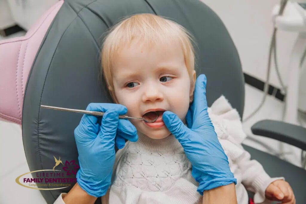 Pediatric dental exam in progress as a dentist checks a toddler’s teeth at Lifetime Family Dentistry.